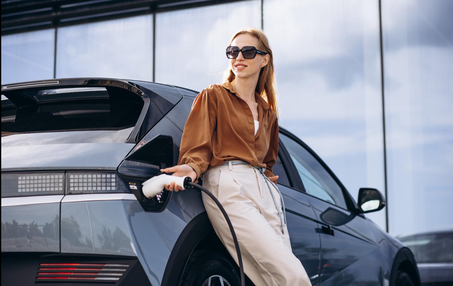 Business woman lädt E-Auto